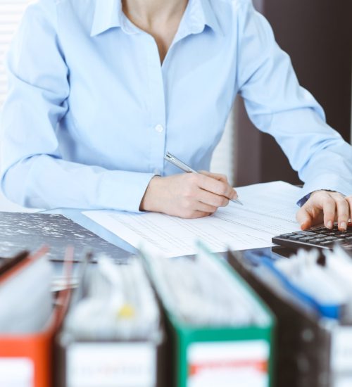 Bookkeeper woman or financial inspector making report, calculating or checking balance, close-up. Business, audit or tax concepts.